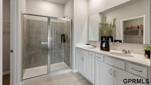 bathroom featuring walk in shower, vanity, and wood-type flooring