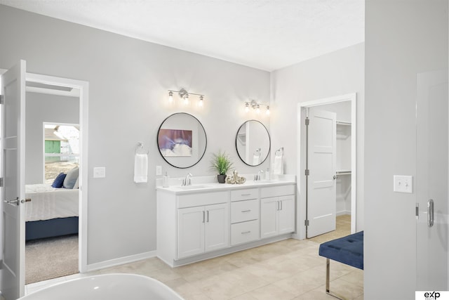 ensuite bathroom with ensuite bathroom, a sink, tile patterned floors, and double vanity