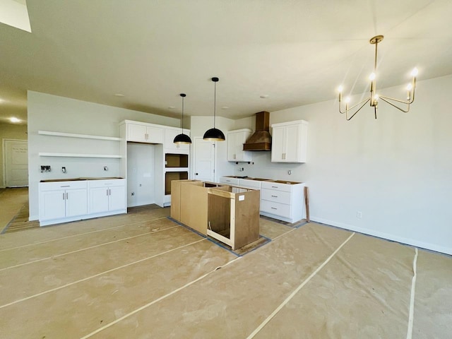 kitchen featuring white cabinets, a chandelier, premium range hood, and a center island