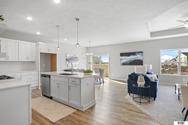 kitchen with a sink, recessed lighting, a textured ceiling, and open floor plan