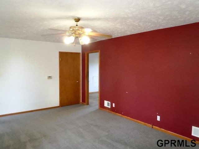 empty room featuring a textured ceiling, ceiling fan, and light colored carpet