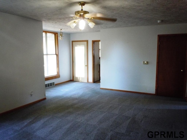 carpeted spare room with ceiling fan and a textured ceiling