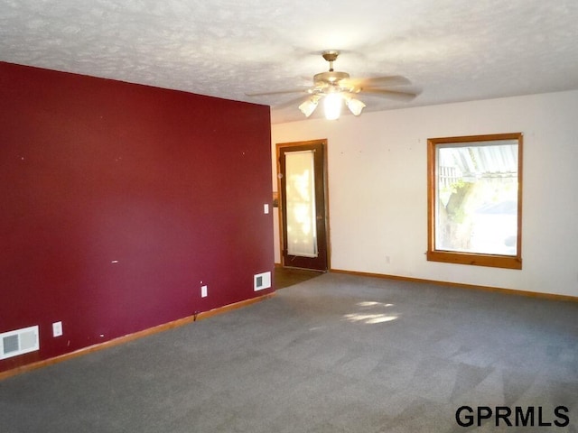 unfurnished room with ceiling fan, a textured ceiling, and carpet