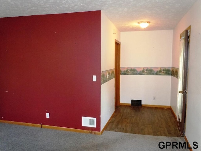 hall featuring a textured ceiling and hardwood / wood-style floors