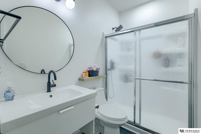 bathroom with vanity, a shower with shower door, and toilet