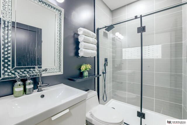 bathroom with walk in shower, vanity, and toilet