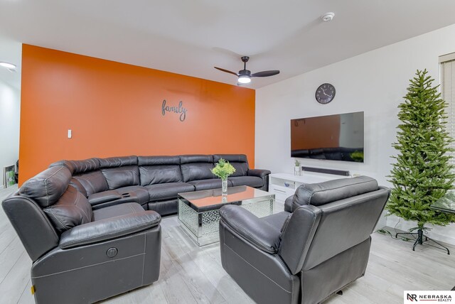 living room with light wood-type flooring and ceiling fan