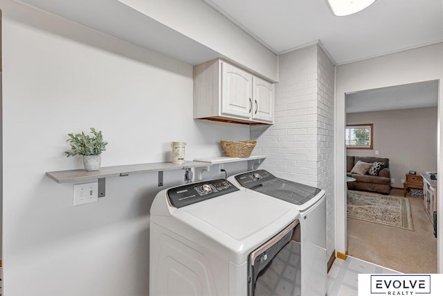 washroom with cabinets and washing machine and clothes dryer