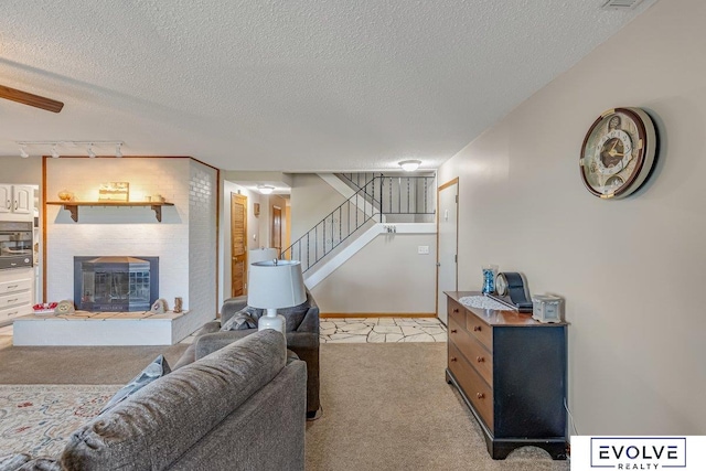 living room with a textured ceiling, light carpet, and track lighting