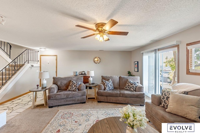 carpeted living room featuring ceiling fan and a textured ceiling