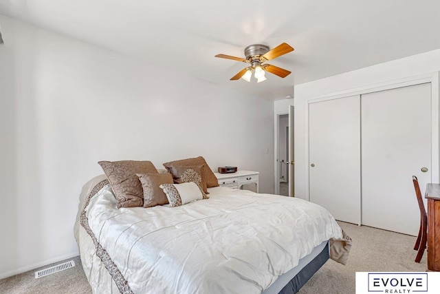 carpeted bedroom with ceiling fan and a closet