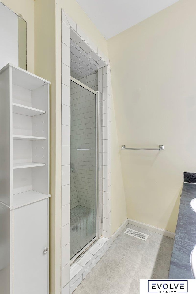 bathroom with walk in shower, tile patterned flooring, and vanity