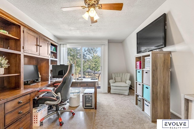 office area with a textured ceiling, light carpet, and ceiling fan