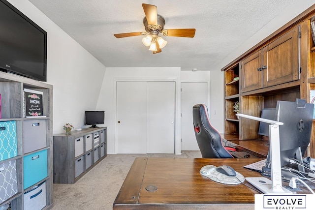 office area with a textured ceiling, ceiling fan, and light colored carpet