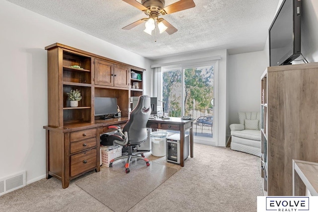 office area with ceiling fan, light colored carpet, and a textured ceiling