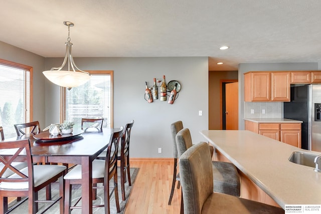 dining space featuring a textured ceiling and light wood-type flooring