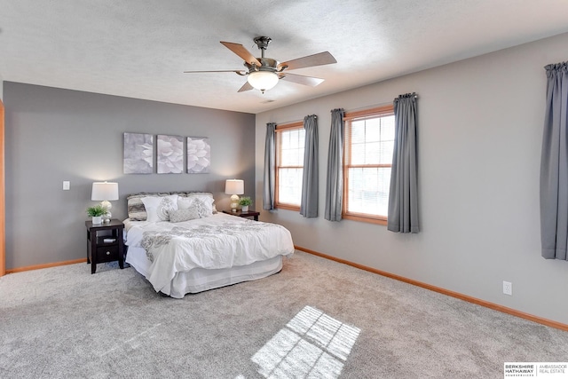 bedroom with a textured ceiling, light carpet, and ceiling fan