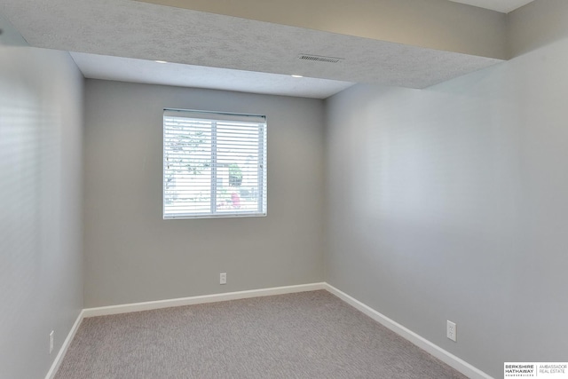 carpeted empty room with a textured ceiling