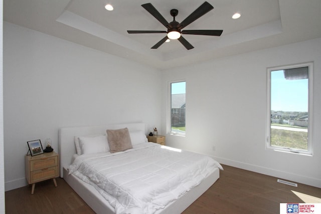 bedroom featuring a tray ceiling, ceiling fan, and dark hardwood / wood-style floors