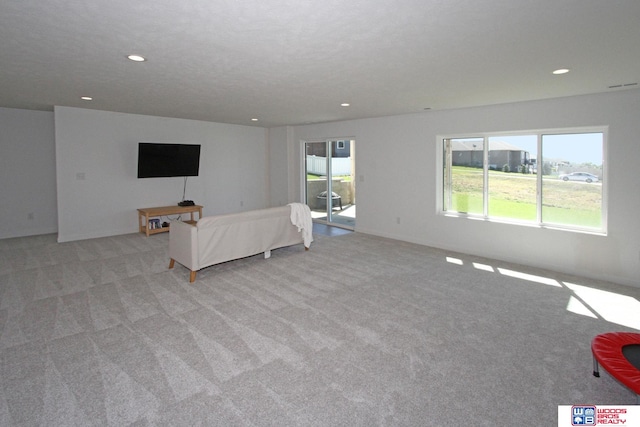 carpeted living room featuring a textured ceiling