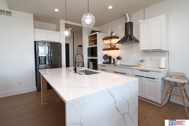 kitchen with sink, white cabinets, wall chimney range hood, a center island with sink, and fridge with ice dispenser