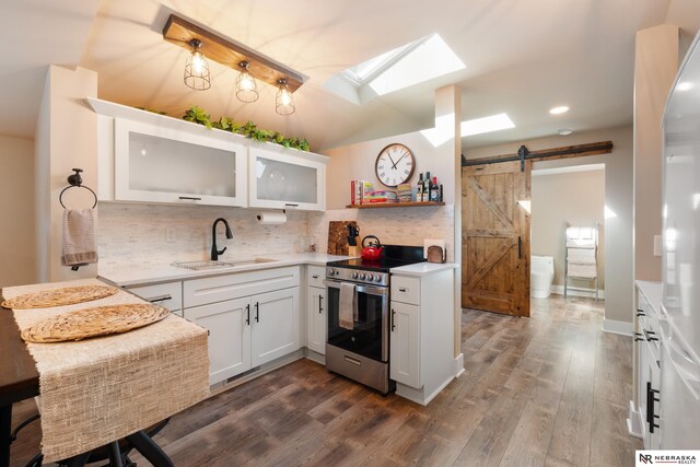 kitchen featuring white cabinetry, dark wood-type flooring, a barn door, sink, and electric range