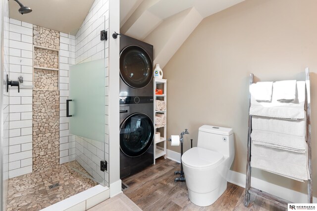 bathroom featuring an enclosed shower, toilet, hardwood / wood-style floors, and stacked washing maching and dryer