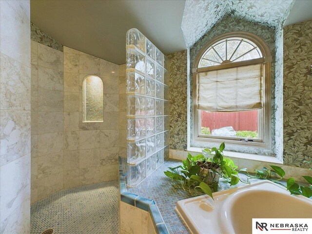 bathroom featuring separate shower and tub and vaulted ceiling