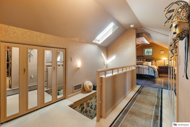 corridor featuring lofted ceiling with skylight