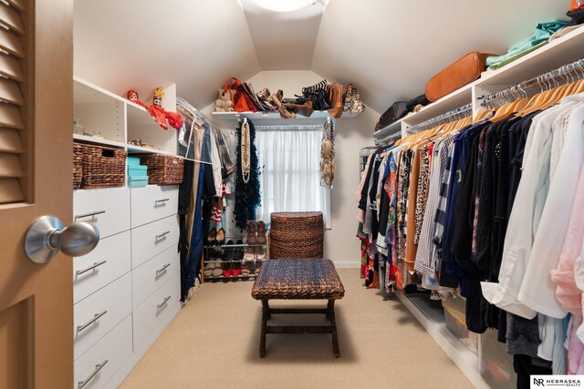 spacious closet with light carpet and vaulted ceiling