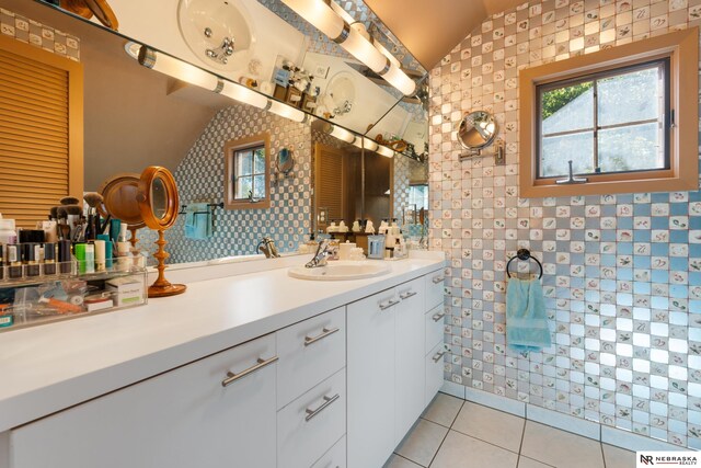 bathroom with vanity, tile patterned flooring, and vaulted ceiling