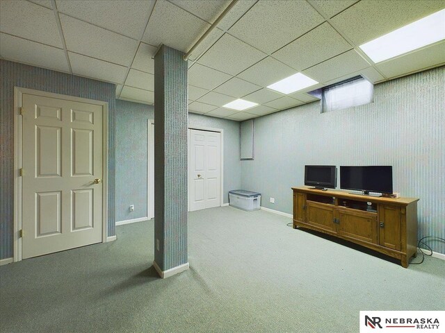 basement featuring a drop ceiling and carpet floors