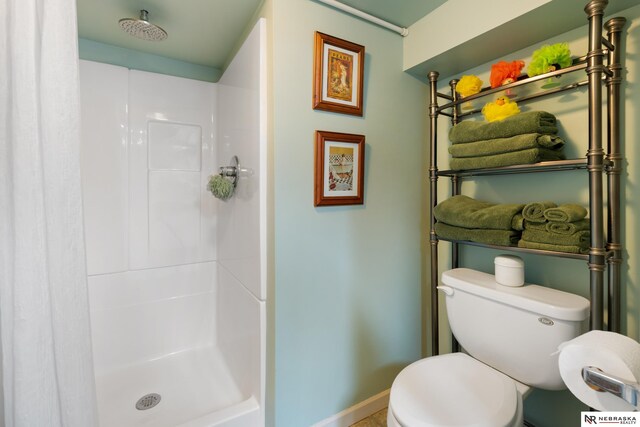 bathroom with toilet and a shower with shower curtain