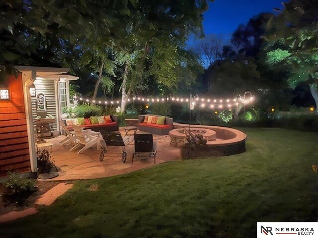 patio at twilight with a lawn and a fire pit