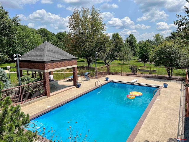 view of pool with a gazebo, a patio area, and a diving board