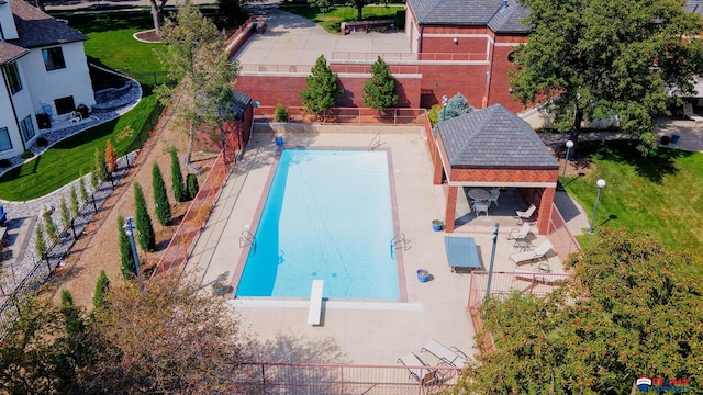 view of swimming pool featuring a patio, a gazebo, a yard, and a diving board