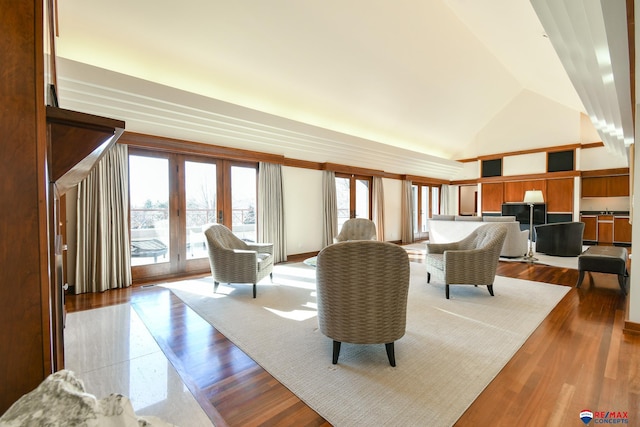 living room featuring light hardwood / wood-style flooring, french doors, and high vaulted ceiling