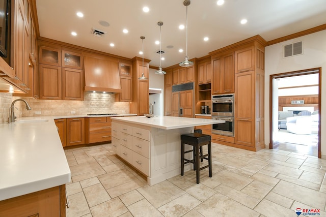 kitchen with sink, decorative backsplash, a center island with sink, decorative light fixtures, and paneled fridge