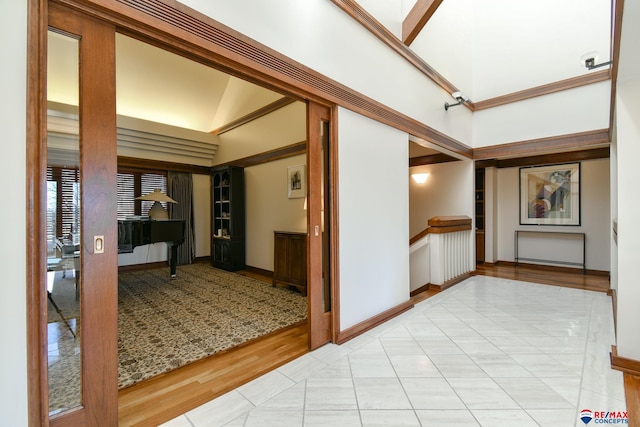 hallway featuring high vaulted ceiling and light wood-type flooring