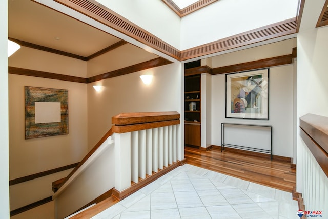 hall featuring light hardwood / wood-style flooring, crown molding, and built in features