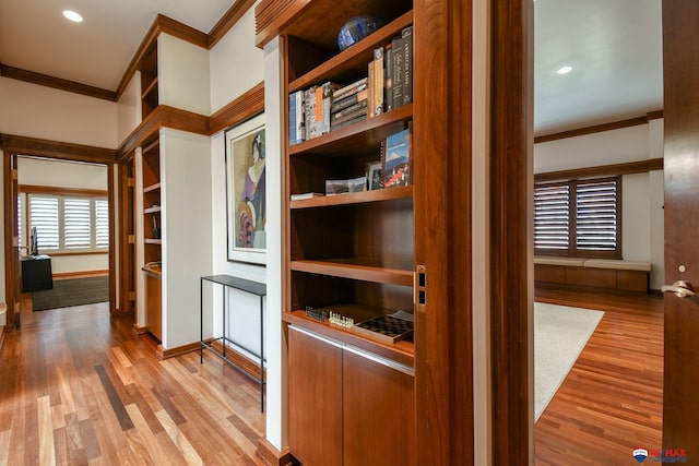 hall featuring ornamental molding and light hardwood / wood-style floors