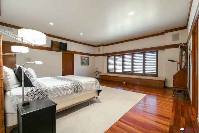 bedroom with ornamental molding and hardwood / wood-style flooring