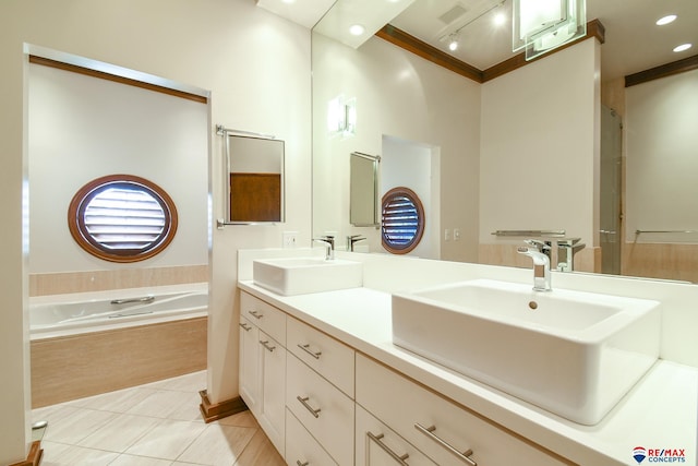 bathroom featuring tiled tub, ornamental molding, vanity, and tile patterned flooring