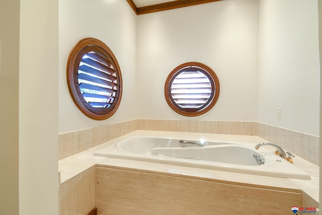 bathroom with a relaxing tiled tub and crown molding