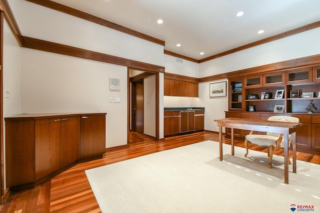 home office with sink, light hardwood / wood-style flooring, and ornamental molding