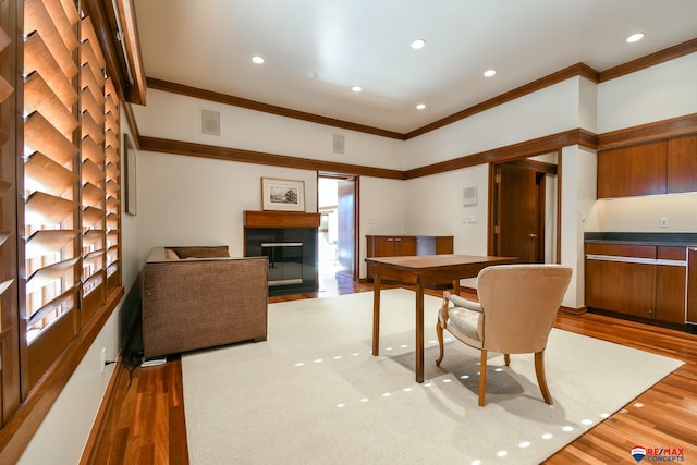 dining space featuring ornamental molding and hardwood / wood-style floors