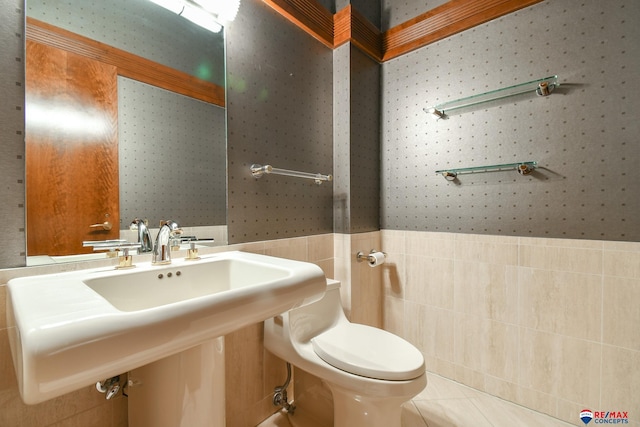 bathroom with tile walls, toilet, and tile patterned floors