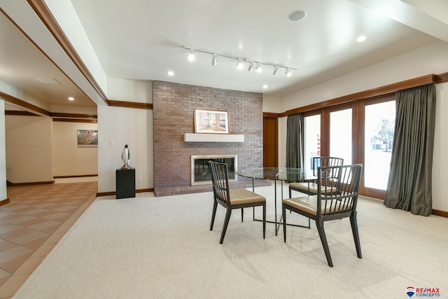 tiled dining space featuring a fireplace and track lighting