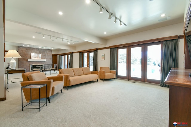 carpeted living room with a brick fireplace and beam ceiling