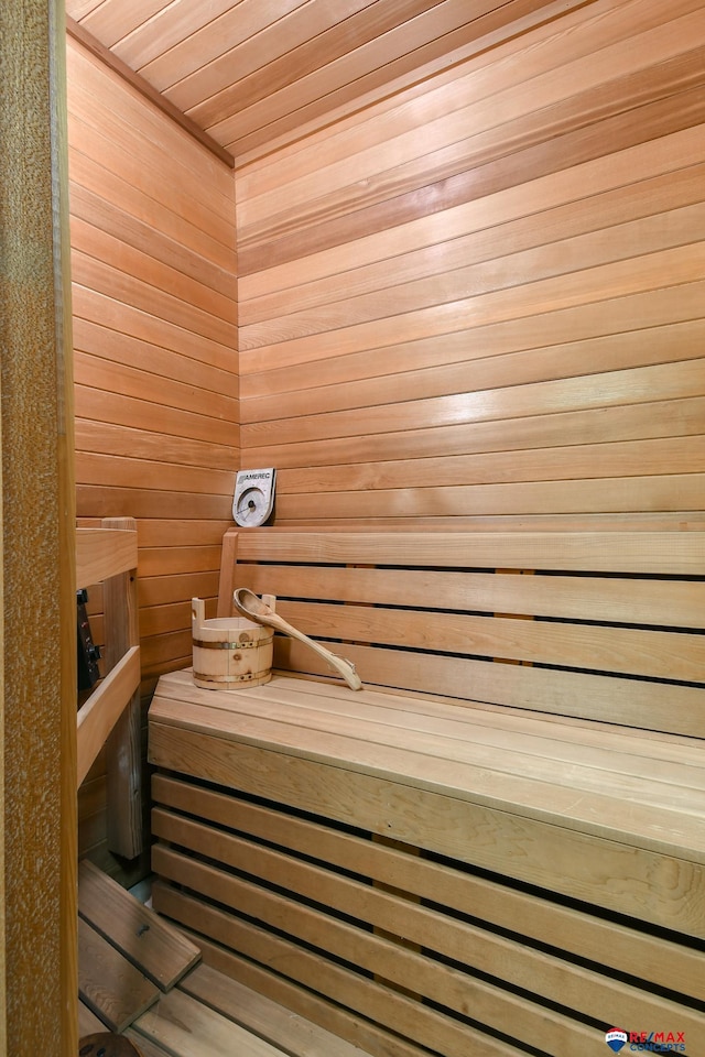 view of sauna featuring wood ceiling and wood walls